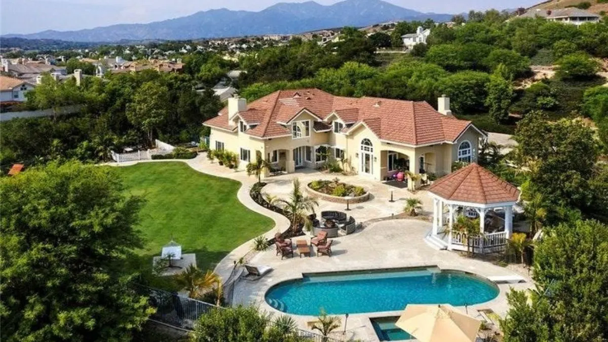 Aerial view of a large estate home with a pool and gazebo