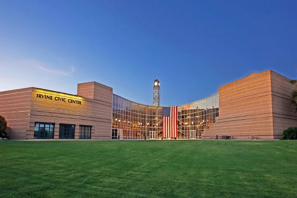 Civic center building with a tall tower and a lawn in front