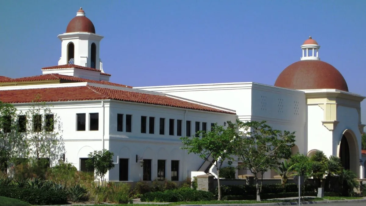White Spanish-style building with a bell tower and red domes