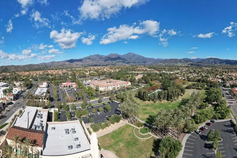Aerial view of a suburban area with parks and mountains in the distance