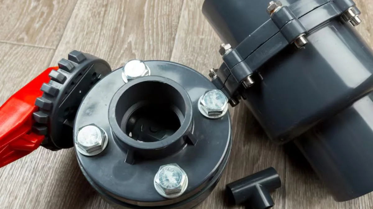 Sump pump check valve and pipe fittings on a wood floor