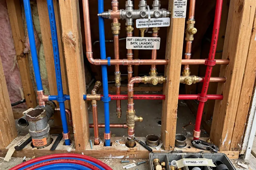 Corroded copper pipe next to new PEX pipe